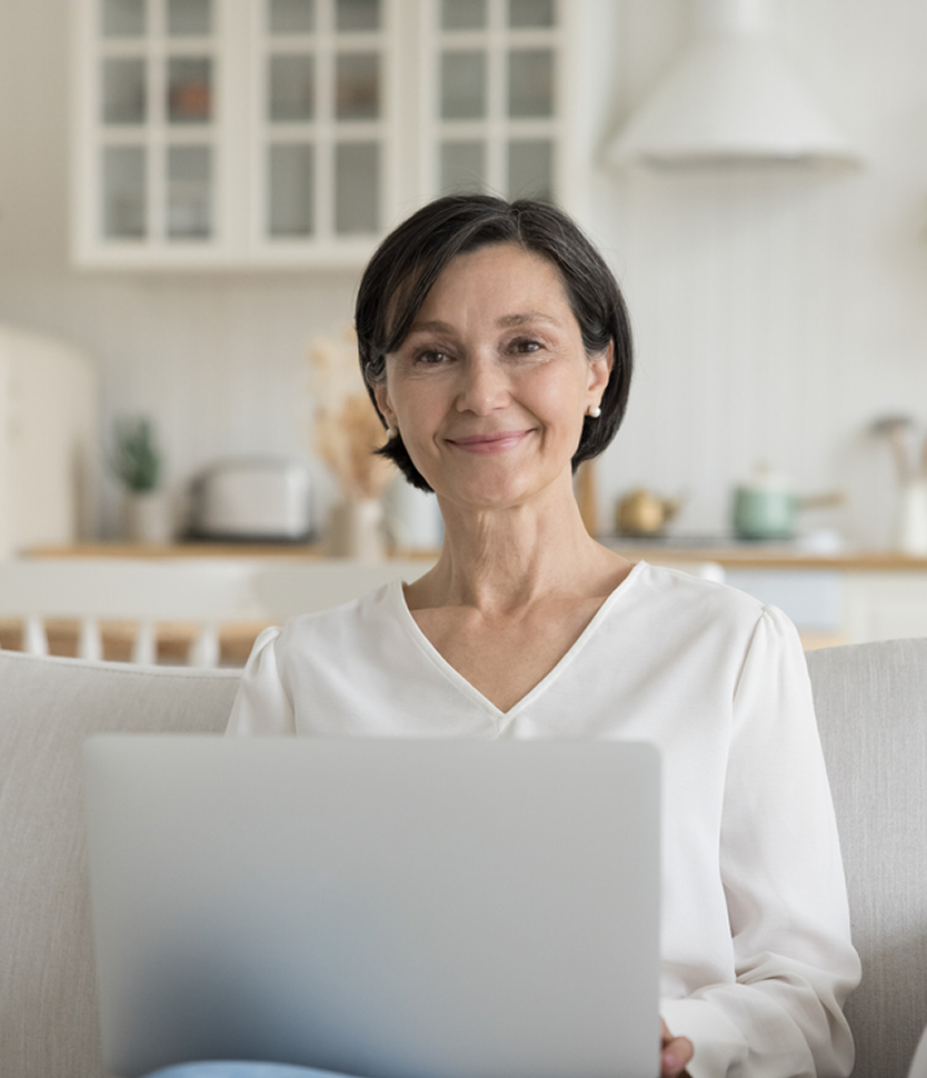 Smiling woman on laptop in a cozy kitchen